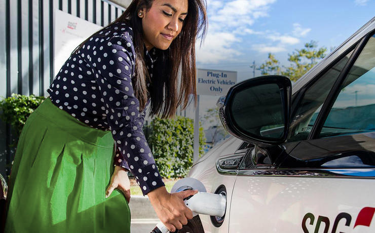 Woman charging an electric car.