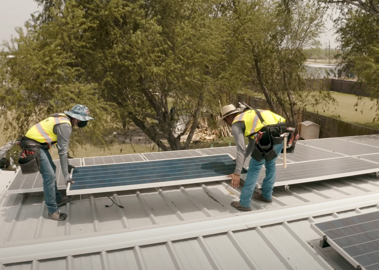 Team members install solar panels