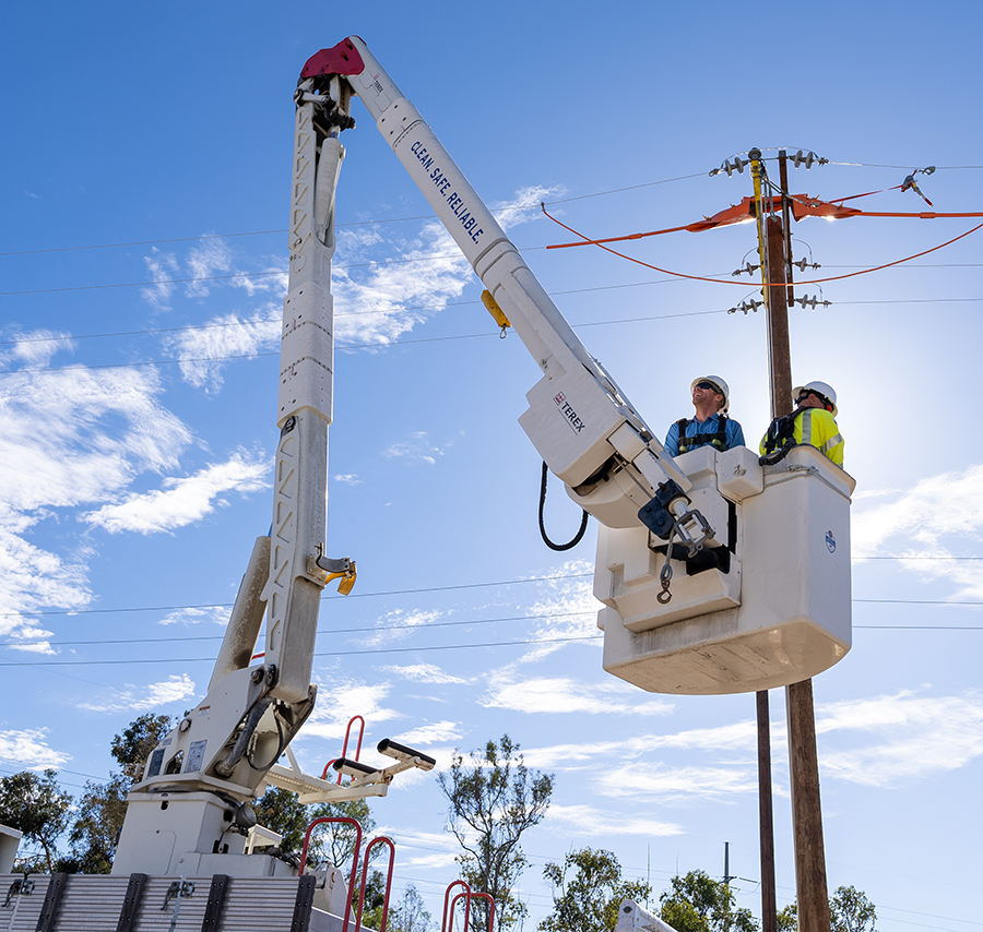 SDG&E team members work on power lines from a bucket truck