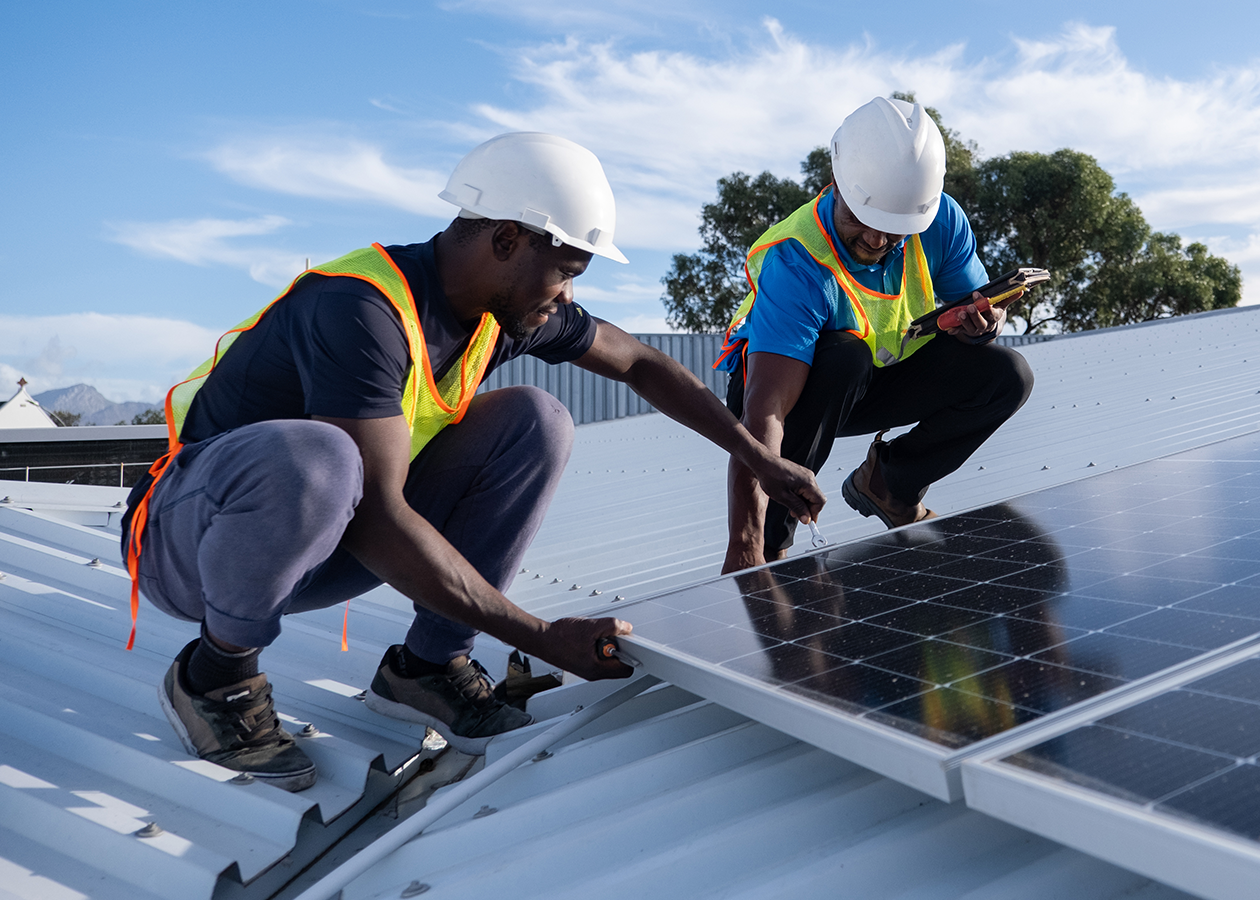 Two workers installing solar panels