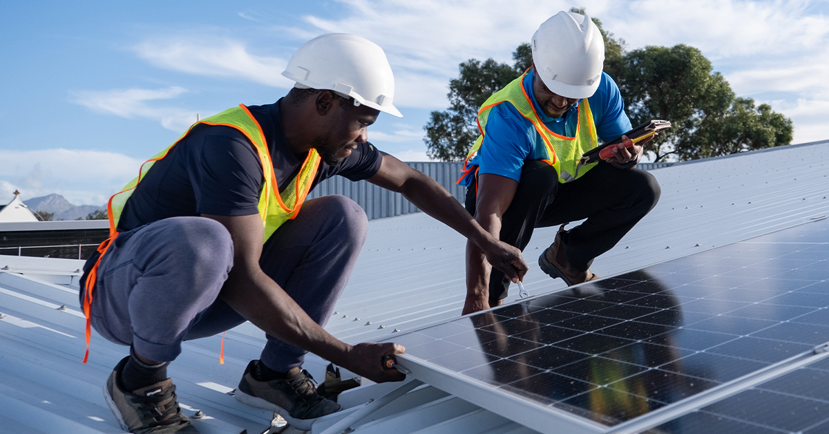Two people installing solar panels