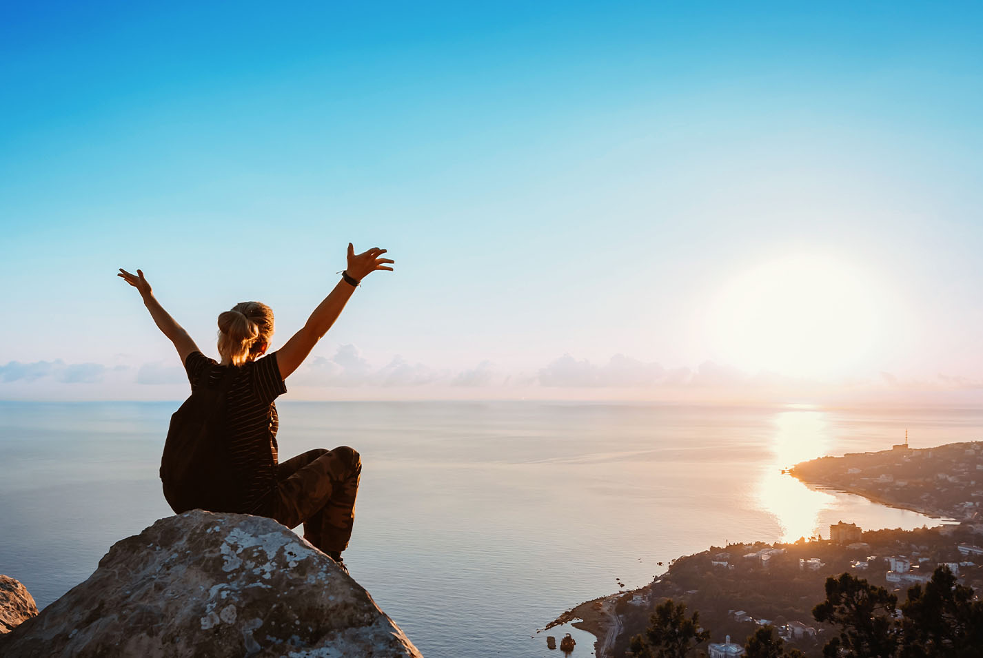 The cover of Sempra's 2024 annual report, depicting a celebrating woman at the top of a mountain.