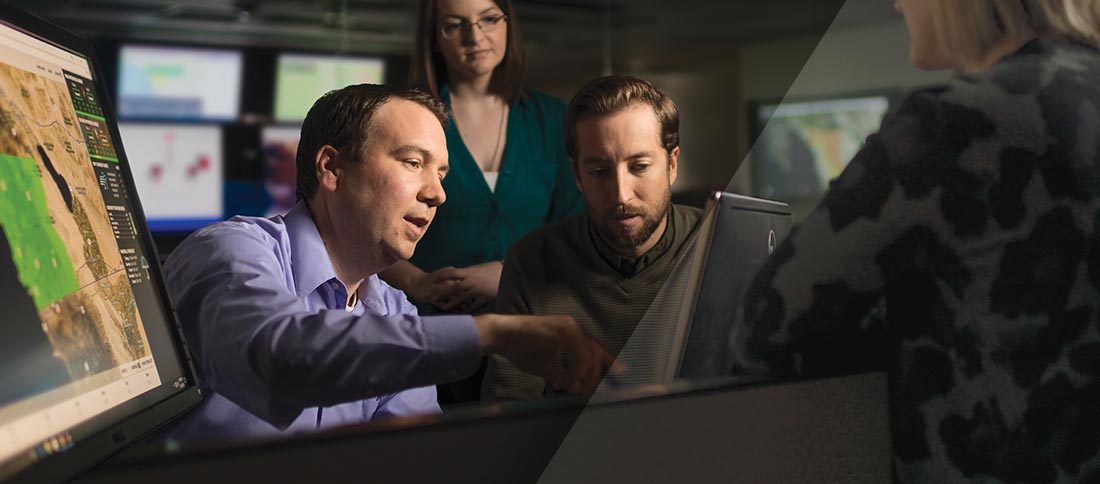 Workers gathered around a computer