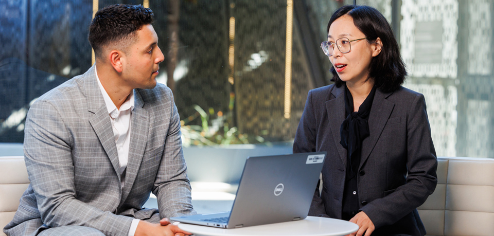 A pair of employees sits and talks together